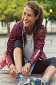 smiling woman tying her sneakers