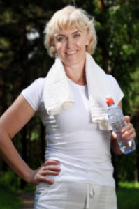 older woman drinking water after exercise 