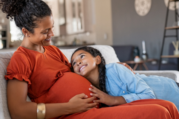 pregnant woman sitting with her daughter