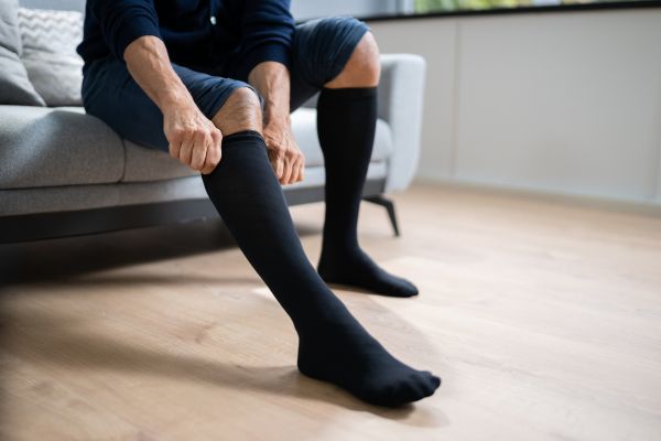 man putting on compression stockings